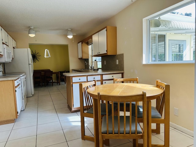 kitchen featuring white appliances, a textured ceiling, tasteful backsplash, ceiling fan, and light tile patterned floors