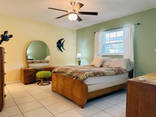 tiled bedroom with ceiling fan and a textured ceiling