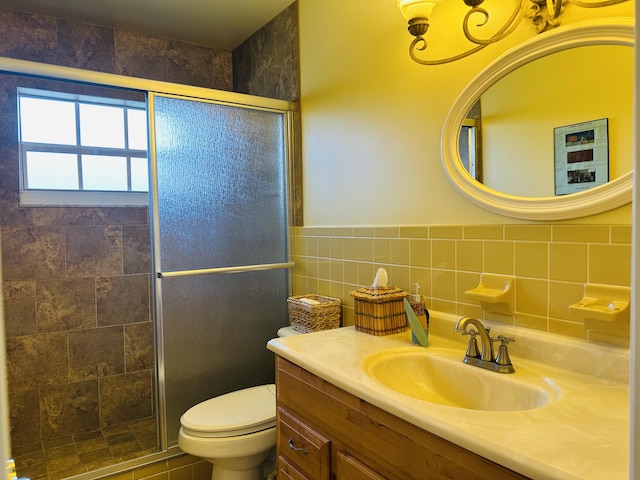 bathroom with toilet, tile walls, a shower with door, and vanity