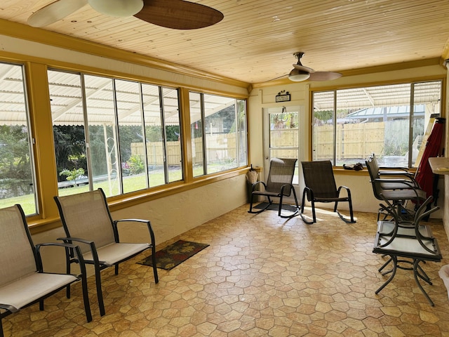 sunroom featuring ceiling fan, a healthy amount of sunlight, and wooden ceiling