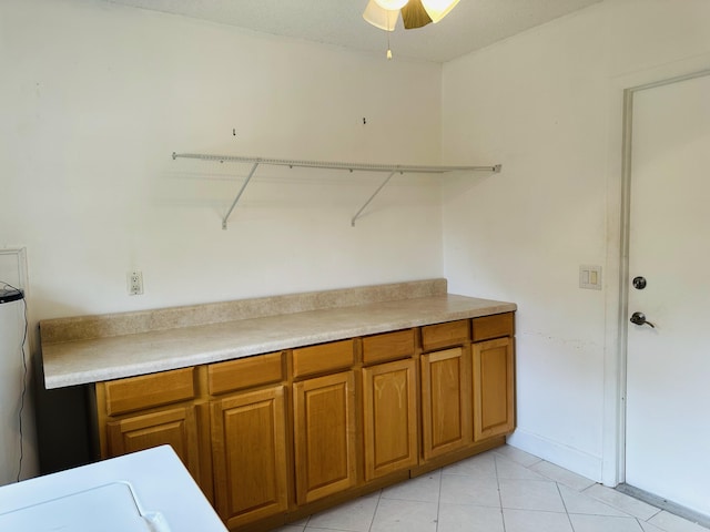 laundry room featuring ceiling fan and light tile patterned floors