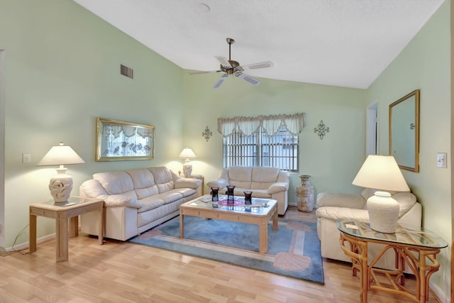 living room with ceiling fan, vaulted ceiling, and light wood-type flooring