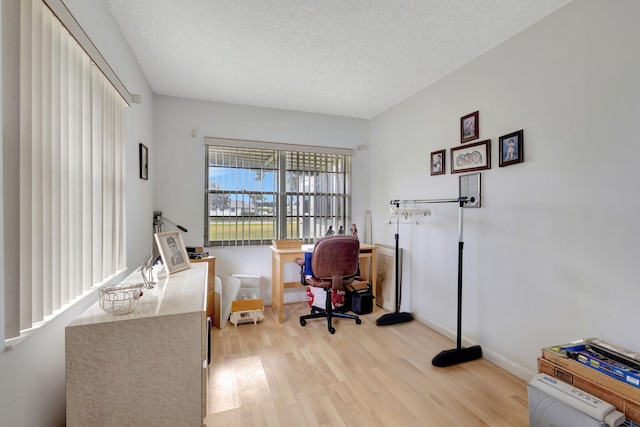 office space featuring a textured ceiling and light wood-type flooring