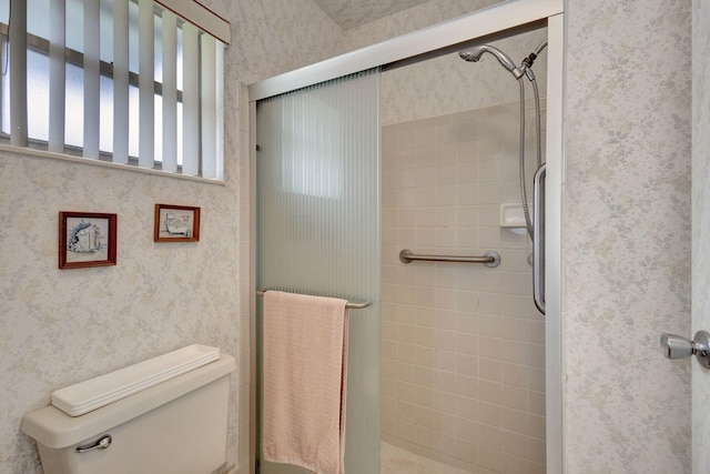 bathroom featuring toilet and an enclosed shower