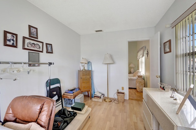 sitting room with light wood-type flooring and a textured ceiling