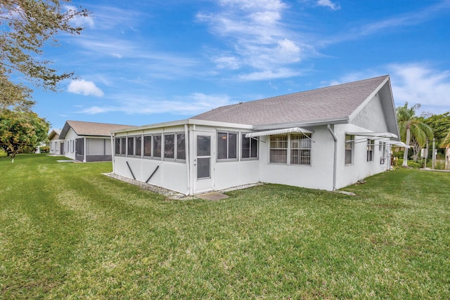 back of house with a sunroom and a lawn