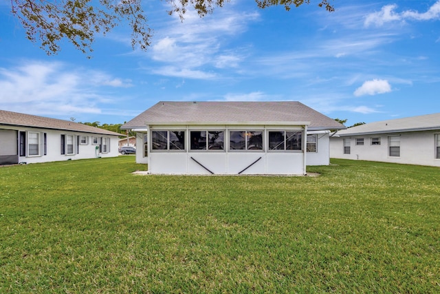 back of property featuring a lawn and a sunroom