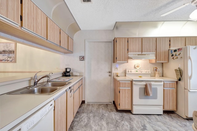 kitchen with white appliances, a textured ceiling, light brown cabinets, sink, and ceiling fan