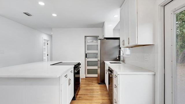 kitchen featuring black appliances, tasteful backsplash, light wood-type flooring, white cabinetry, and sink