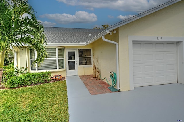 property entrance featuring a yard and a garage