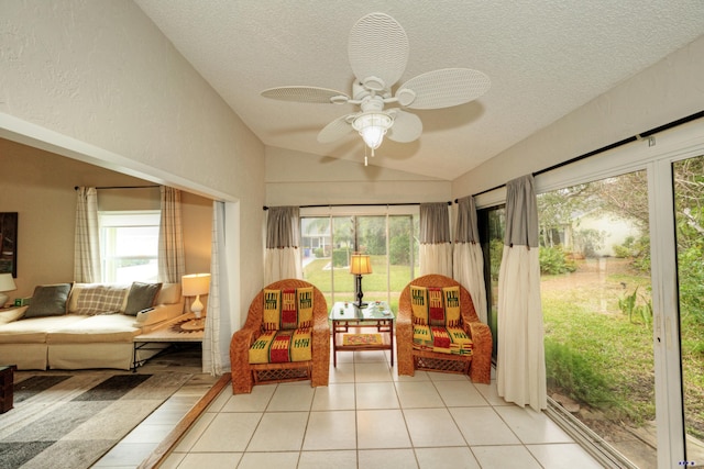 sunroom with ceiling fan, plenty of natural light, and vaulted ceiling