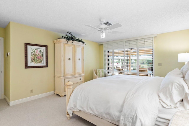 carpeted bedroom with a textured ceiling and ceiling fan