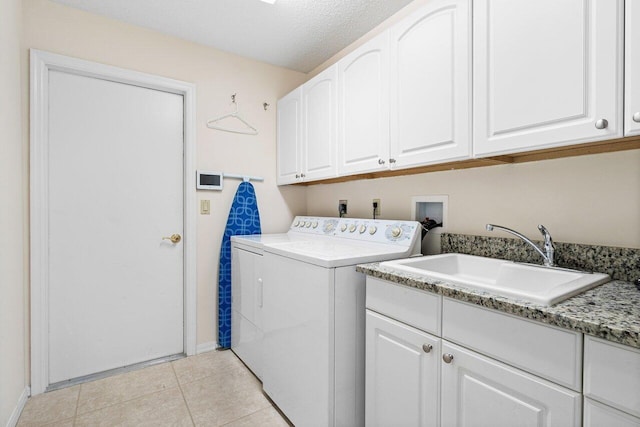 laundry area featuring sink, light tile patterned floors, cabinets, washing machine and clothes dryer, and a textured ceiling