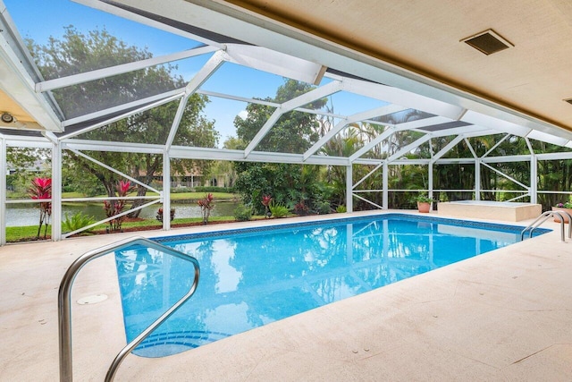 view of pool with glass enclosure and a patio area