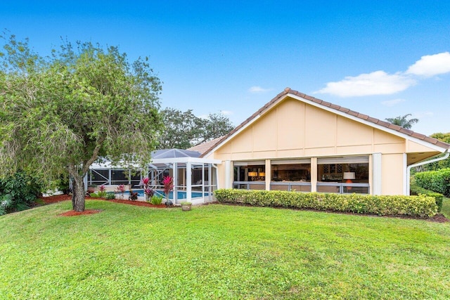 rear view of property featuring a yard and a lanai