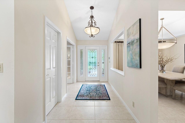 entryway with light tile patterned floors and vaulted ceiling