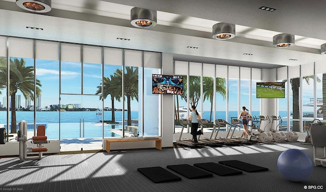 exercise room with carpet and a water view