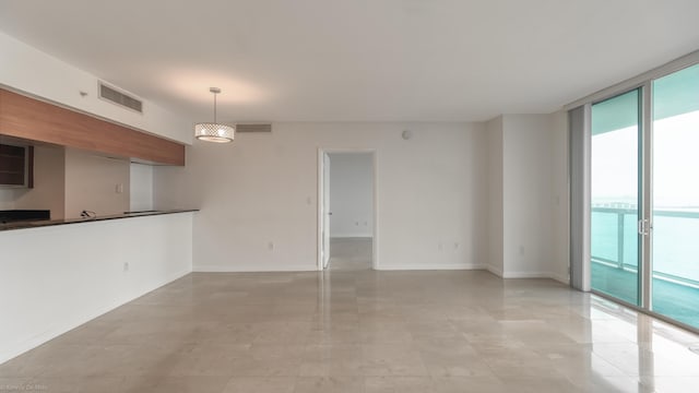 unfurnished living room with floor to ceiling windows and a water view