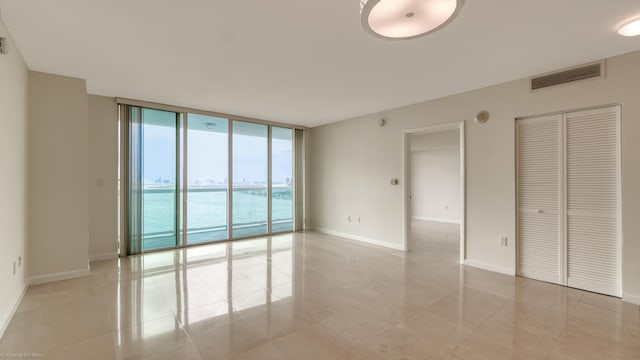 interior space with floor to ceiling windows and a water view