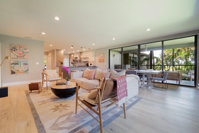 living room featuring light wood-type flooring and a wall of windows