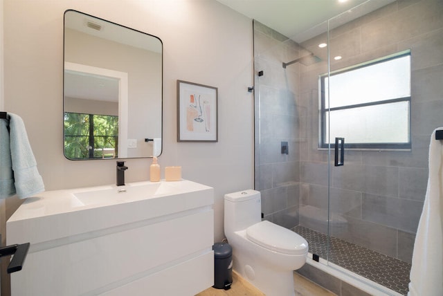 bathroom with toilet, an enclosed shower, and vanity