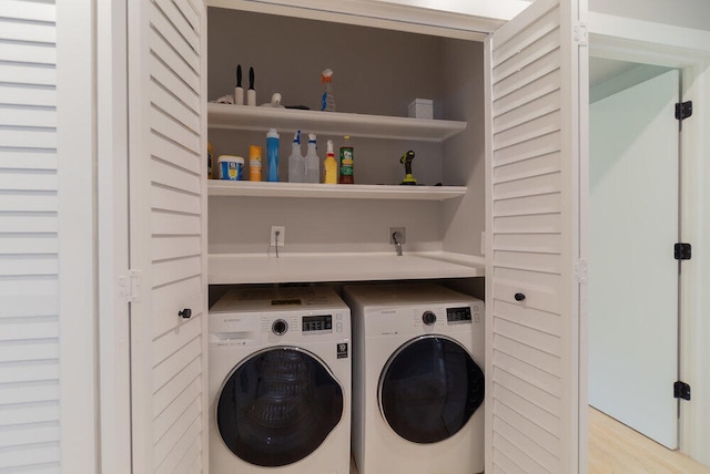 laundry area with light wood-type flooring and washing machine and clothes dryer