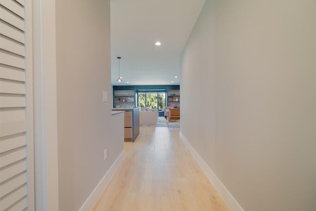 hallway featuring built in features and light hardwood / wood-style floors