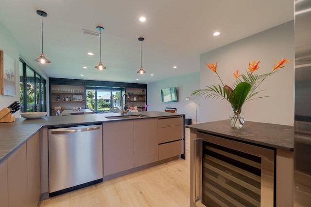 kitchen featuring decorative light fixtures, stainless steel dishwasher, beverage cooler, and sink