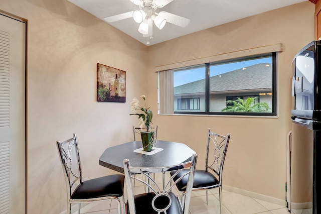 tiled dining space featuring baseboards and a ceiling fan