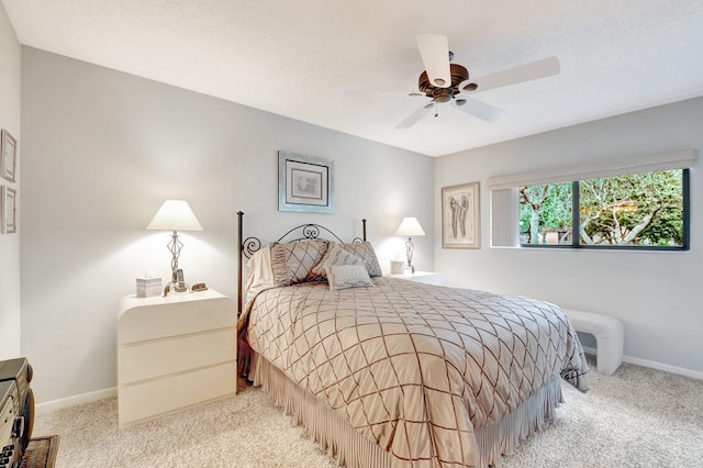 carpeted bedroom with a ceiling fan and baseboards