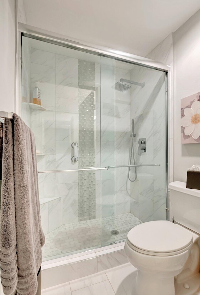 bathroom with a shower stall and toilet