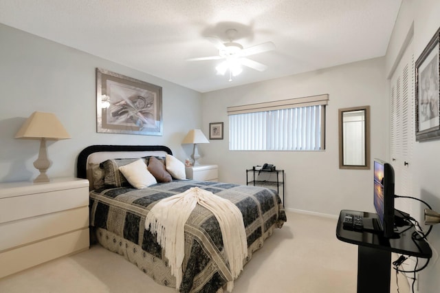 bedroom with carpet flooring, a textured ceiling, a ceiling fan, and baseboards