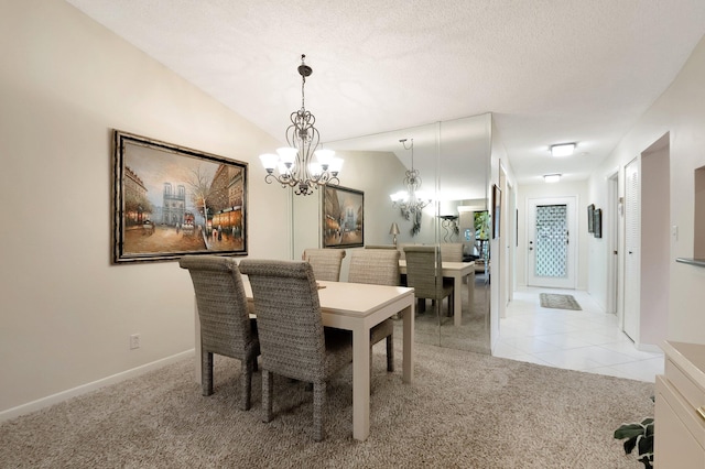 dining space featuring light carpet, a notable chandelier, a textured ceiling, light tile patterned floors, and vaulted ceiling