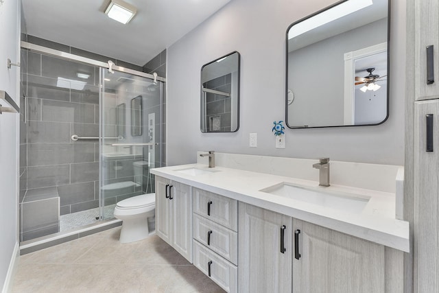 bathroom featuring toilet, ceiling fan, tile patterned floors, walk in shower, and vanity