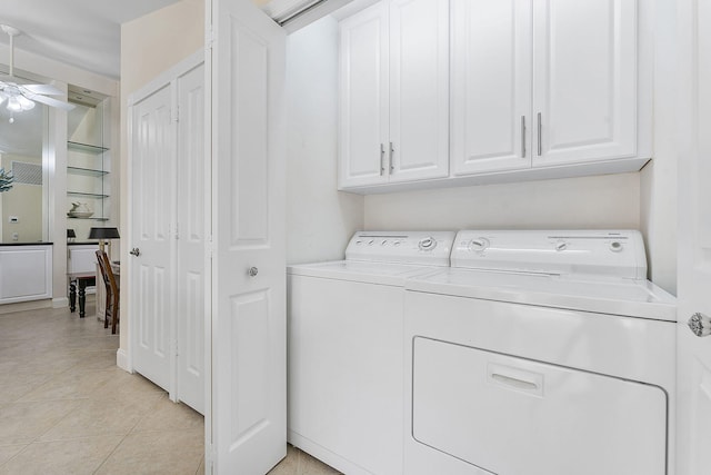 laundry area featuring cabinets, light tile patterned flooring, washing machine and clothes dryer, and ceiling fan