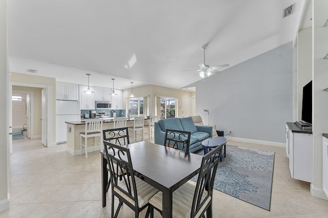 tiled dining area featuring ceiling fan and vaulted ceiling