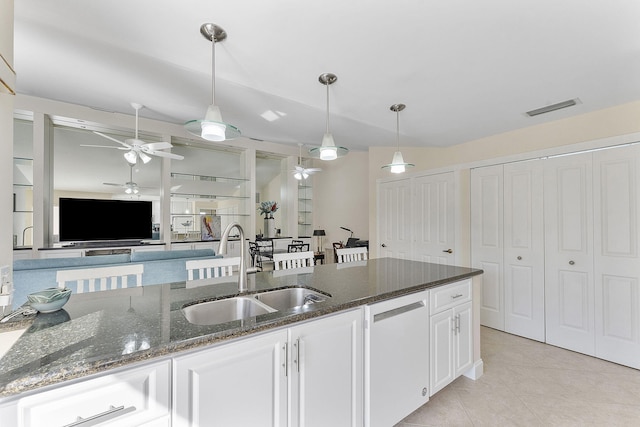 kitchen with white cabinets, dark stone countertops, sink, hanging light fixtures, and white dishwasher