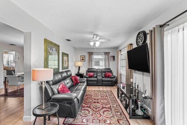 living room with ceiling fan and light hardwood / wood-style floors