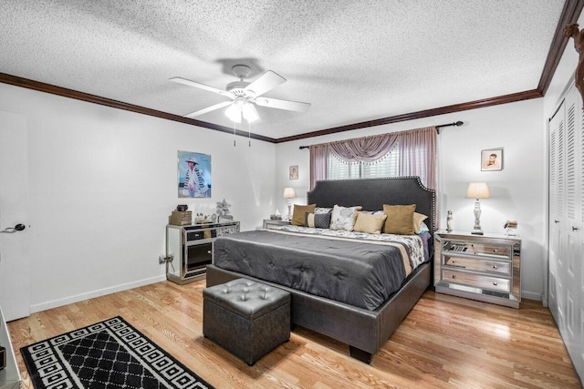 bedroom with a textured ceiling, wood-type flooring, ceiling fan, and a closet