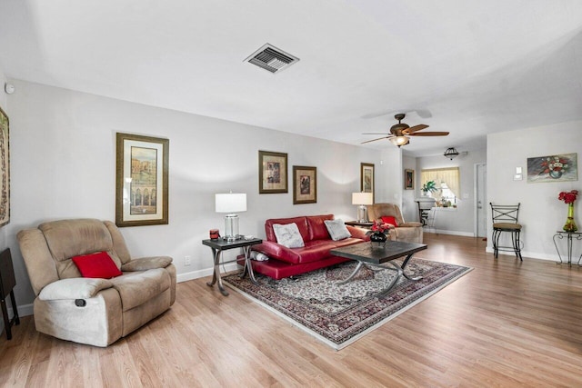 living room featuring wood-type flooring and ceiling fan