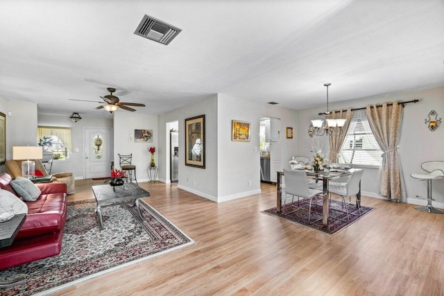 living room featuring light hardwood / wood-style flooring and ceiling fan with notable chandelier