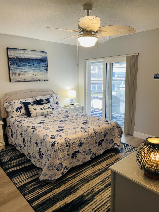 bedroom with a textured ceiling, ceiling fan, access to exterior, and hardwood / wood-style flooring