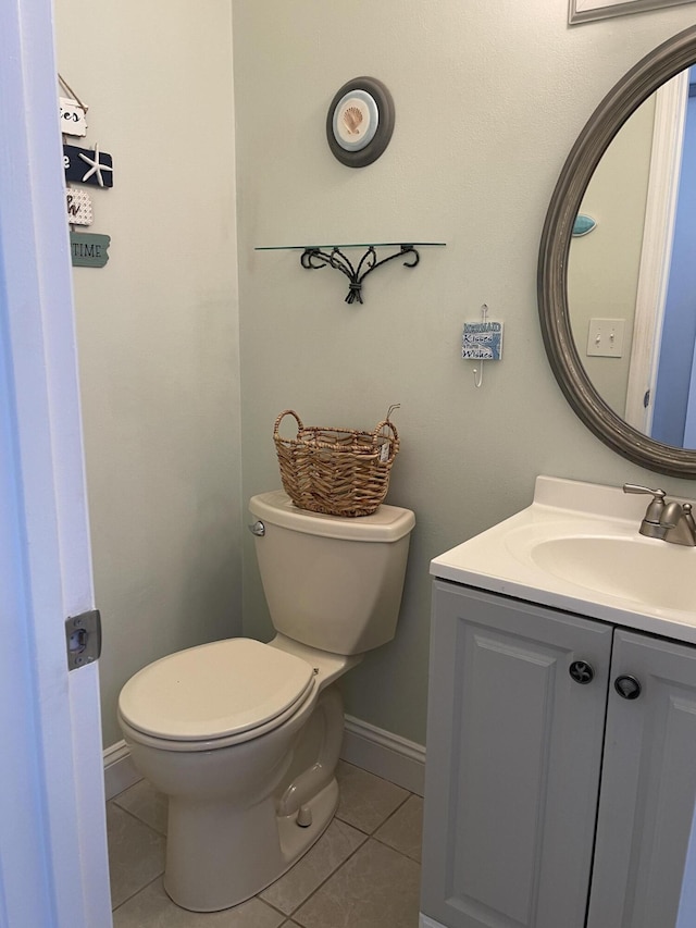 bathroom with toilet, vanity, and tile patterned flooring