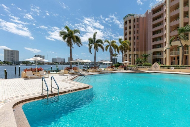 view of pool with a water view and a patio