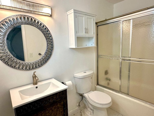 full bathroom featuring combined bath / shower with glass door, vanity, tile patterned floors, and toilet