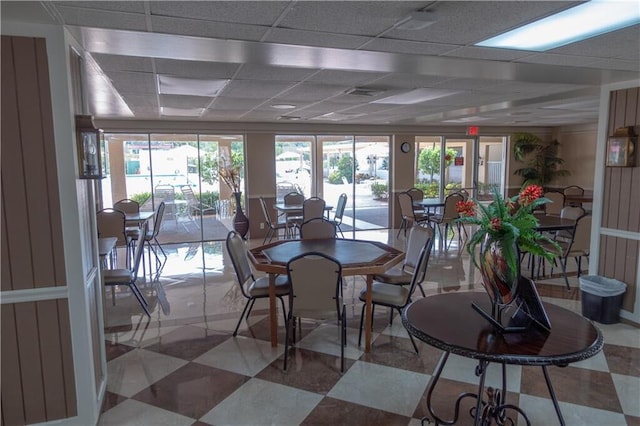 interior space featuring a paneled ceiling and light tile patterned flooring