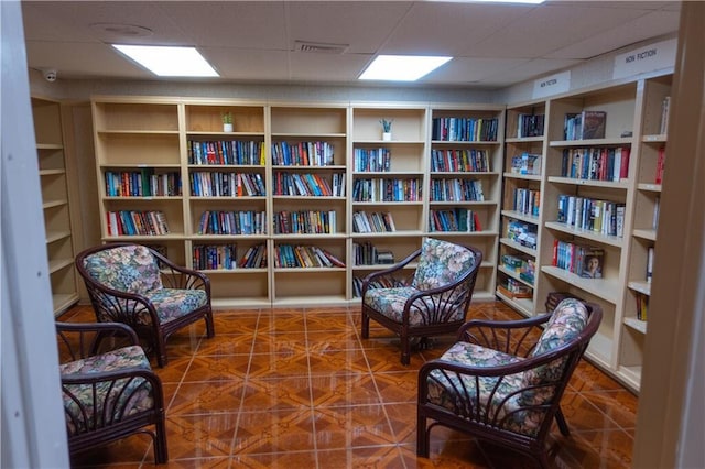 sitting room featuring a paneled ceiling and tile patterned flooring