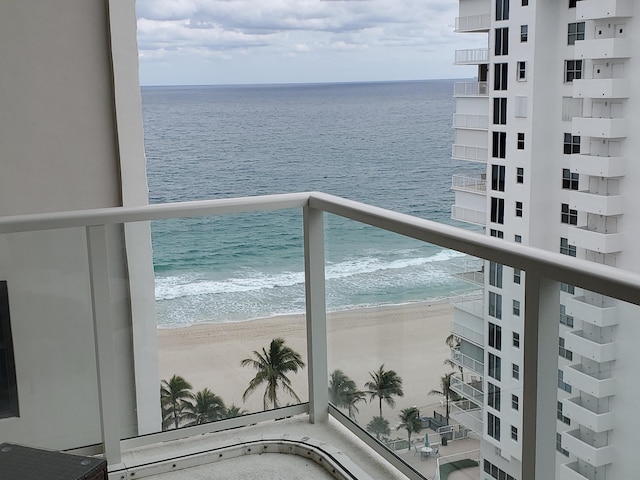 balcony featuring a view of the beach and a water view