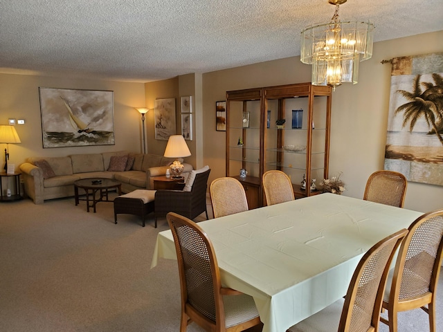 dining area with an inviting chandelier, a textured ceiling, and carpet