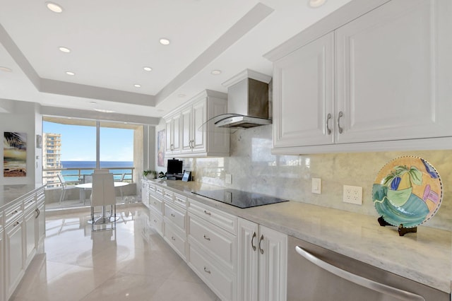 kitchen featuring tasteful backsplash, black electric stovetop, white cabinets, wall chimney exhaust hood, and light stone counters